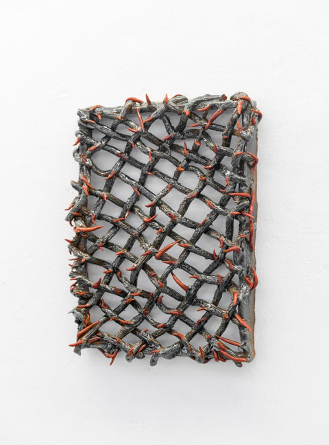 A ceramic sculpture of thorns with red ends. 